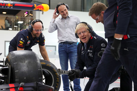 رئيس الوزراء البريطاني بوريس جونسون يغير عجلة في سيارة فورمولا 1