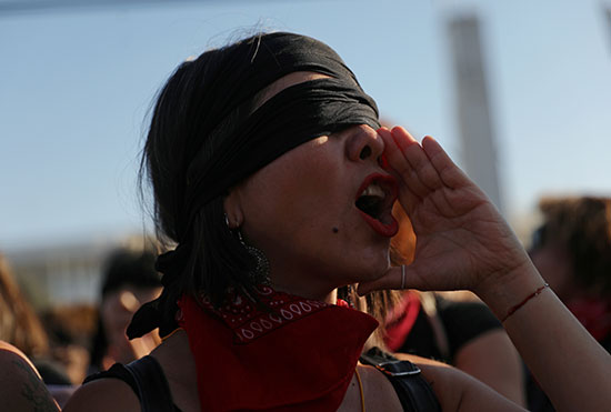 امرأة ترتدى عصابة سوداء تهتف فى مظاهرة نسائية مناهضة للعنف ضد المرأة
