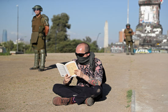 الاحتجاج بالقراءة.. متظاهر يقرأ كتاب أمام قوات الأمن