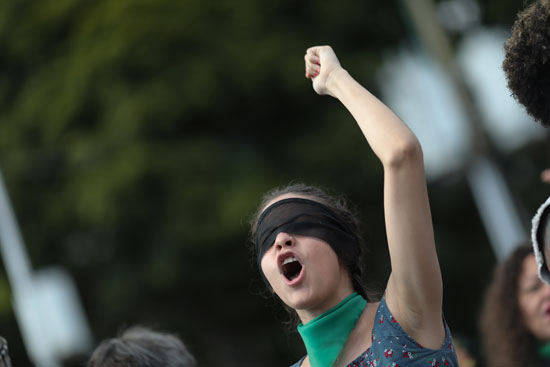 امرأة تغطي عينيها قبل مظاهرة مناهضة للعنف ضد المرأة
