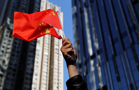متظاهر يرفع العلم الصينى