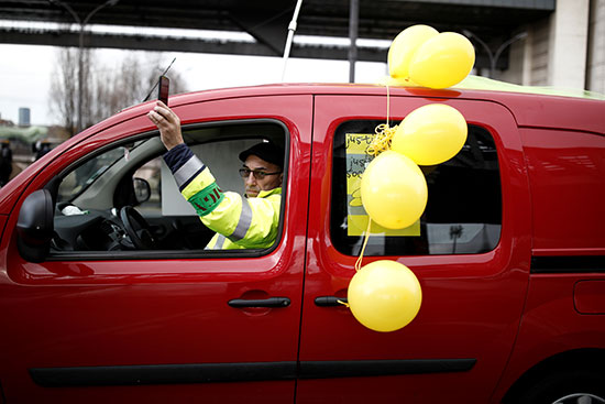 متظاهر يمر بسيارته وسط الاحتجاجات ويرفع بعض البالونات