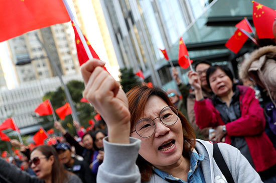 سيدة تلوح بالعلم الصينى خلال المظاهرات