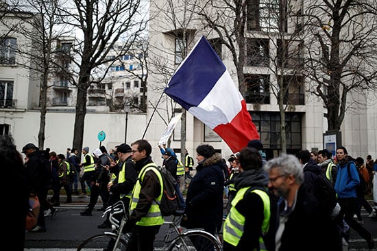 مرتدو السترات الصفراء يرفعون العلم الفرنسى خلال احتجاجاتهم