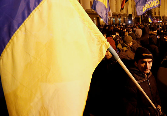 متظاهر يلوح بعلم أوكرانيا خلال الاحتجاجات