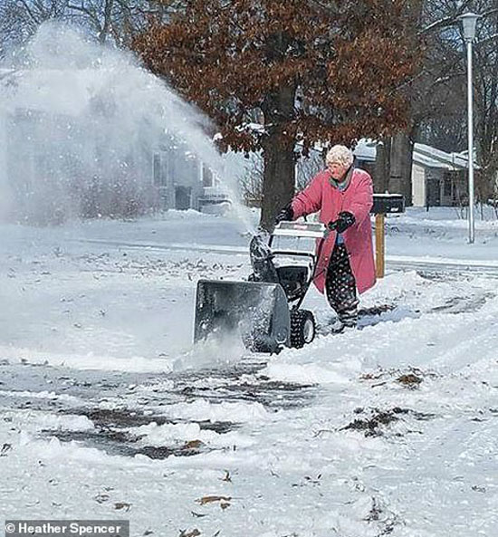 ارمأة تبلغ من العمر 82 عاما تحاول ازالة الثلوج من الطريق