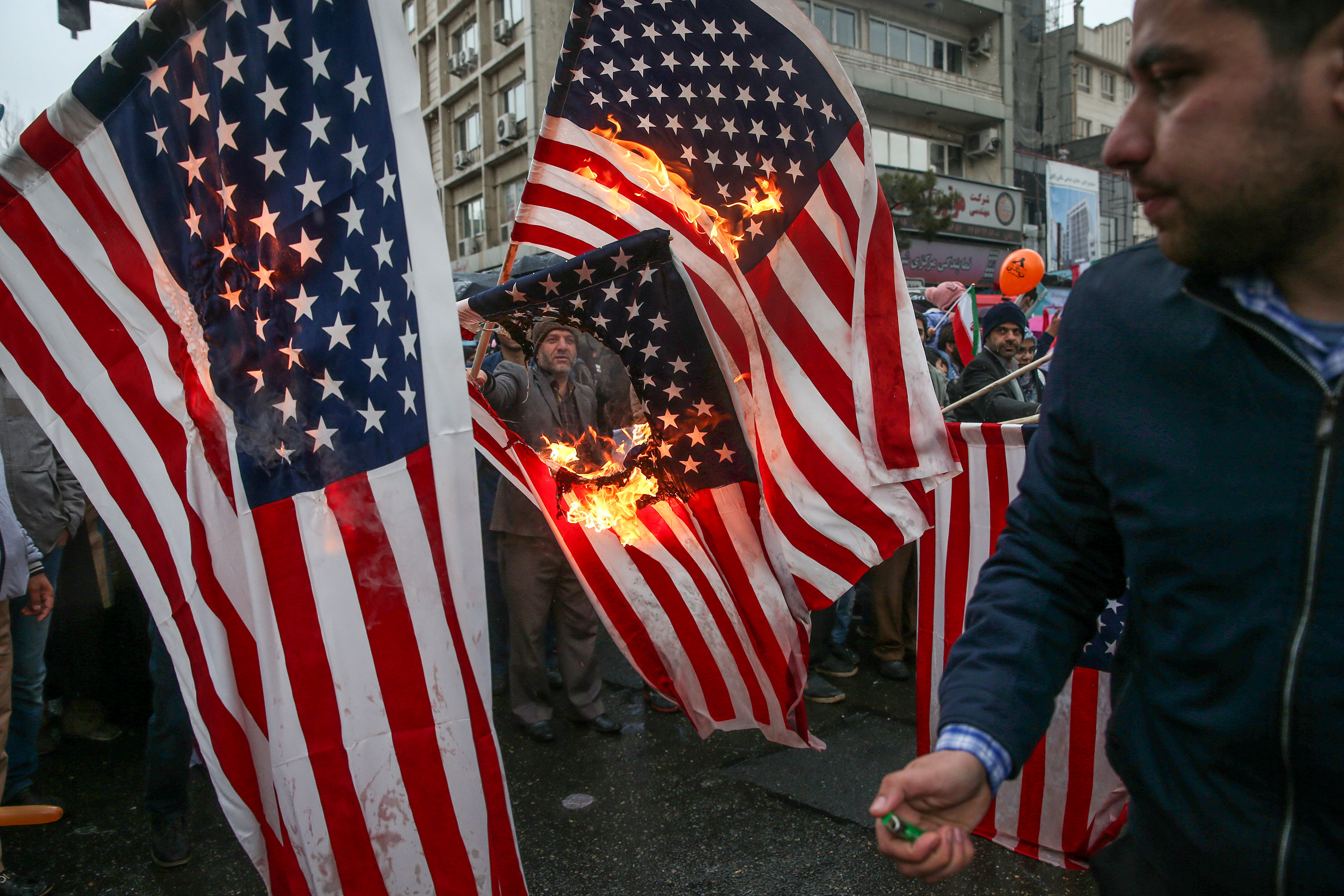 محتفلون بذكرى الثورة يحرقون الأعلام الأمريكية بالشوارع
