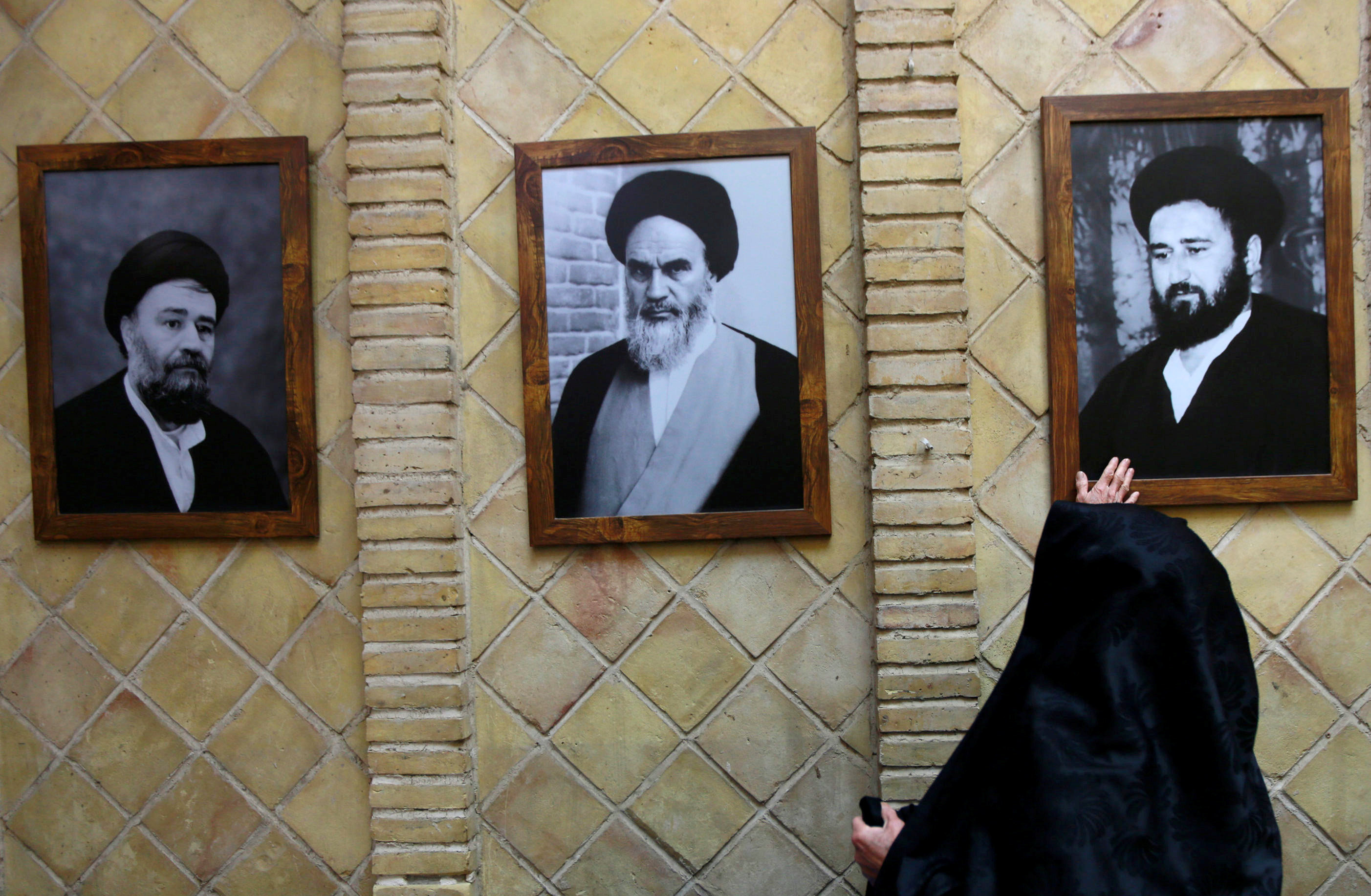 سيدة إيرانية تتبرك بصورة أحد مرشدى الثورة الإيرانية بمنزل الخمينى