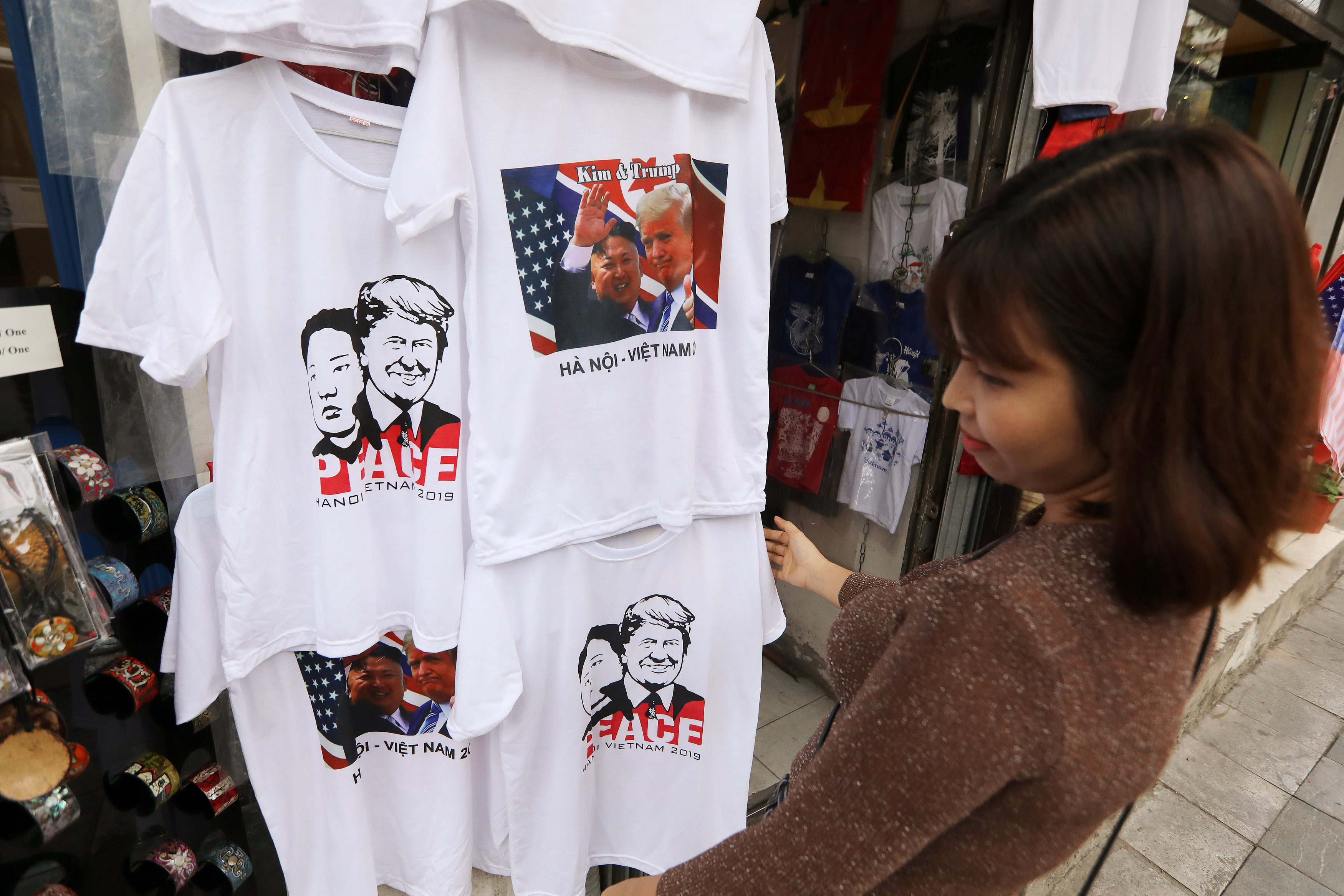مواطنة تنظر إلى ملابس مطبوع عليها صورة زعيمى قمة فيتنام