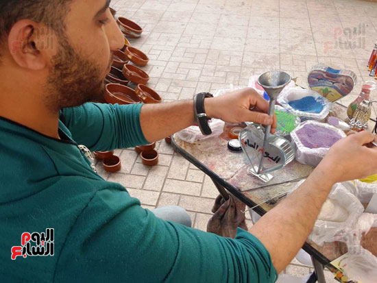 عمر تحدى البطالة فتعلم الرسم على  الرمال ووقف بشوارع اسيوط يعرض موهبته (7)
