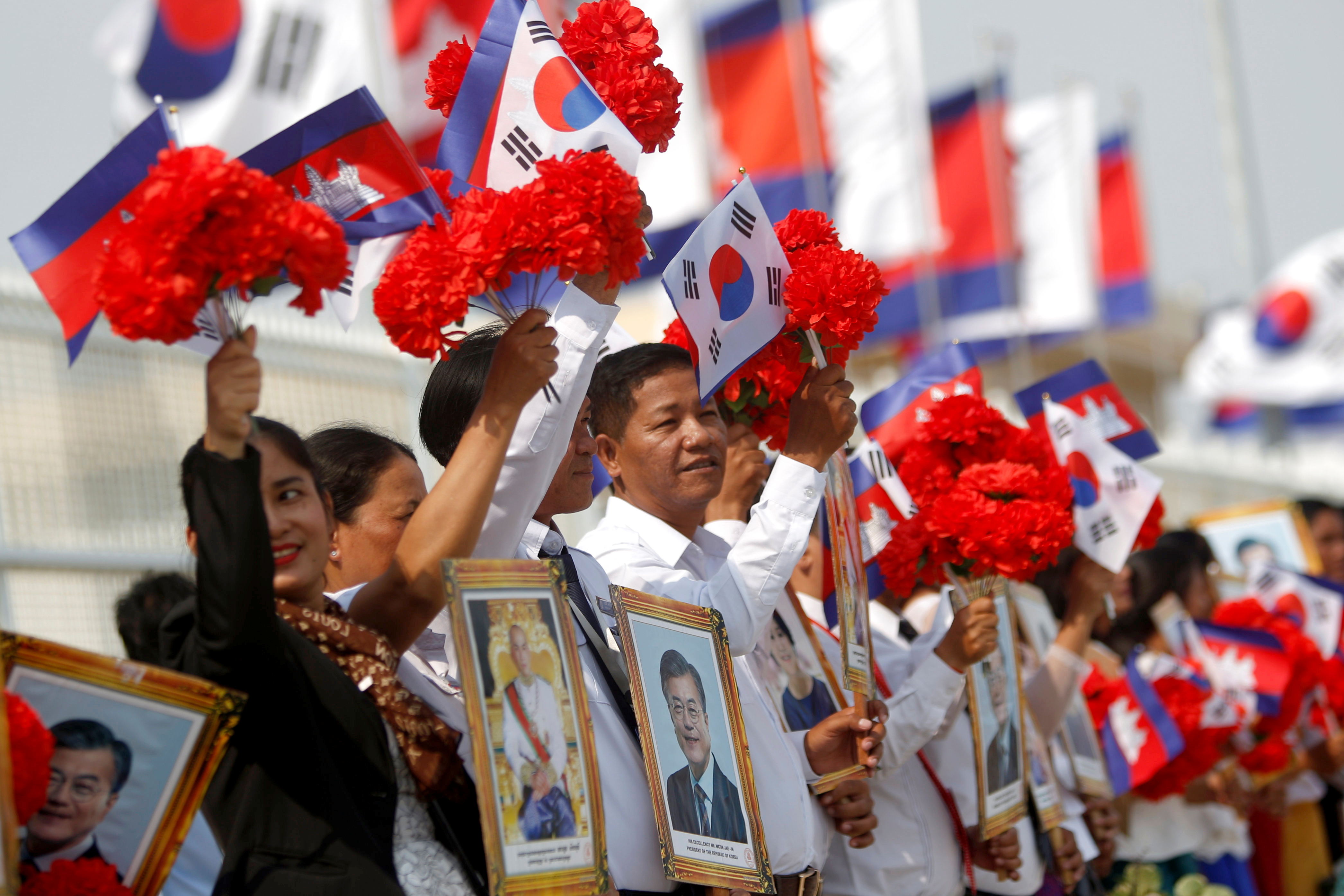 مواطنو كمبوديا يلوحون بأعلام كوريا الجنوبية إلى جانب أعلام بلادهم
