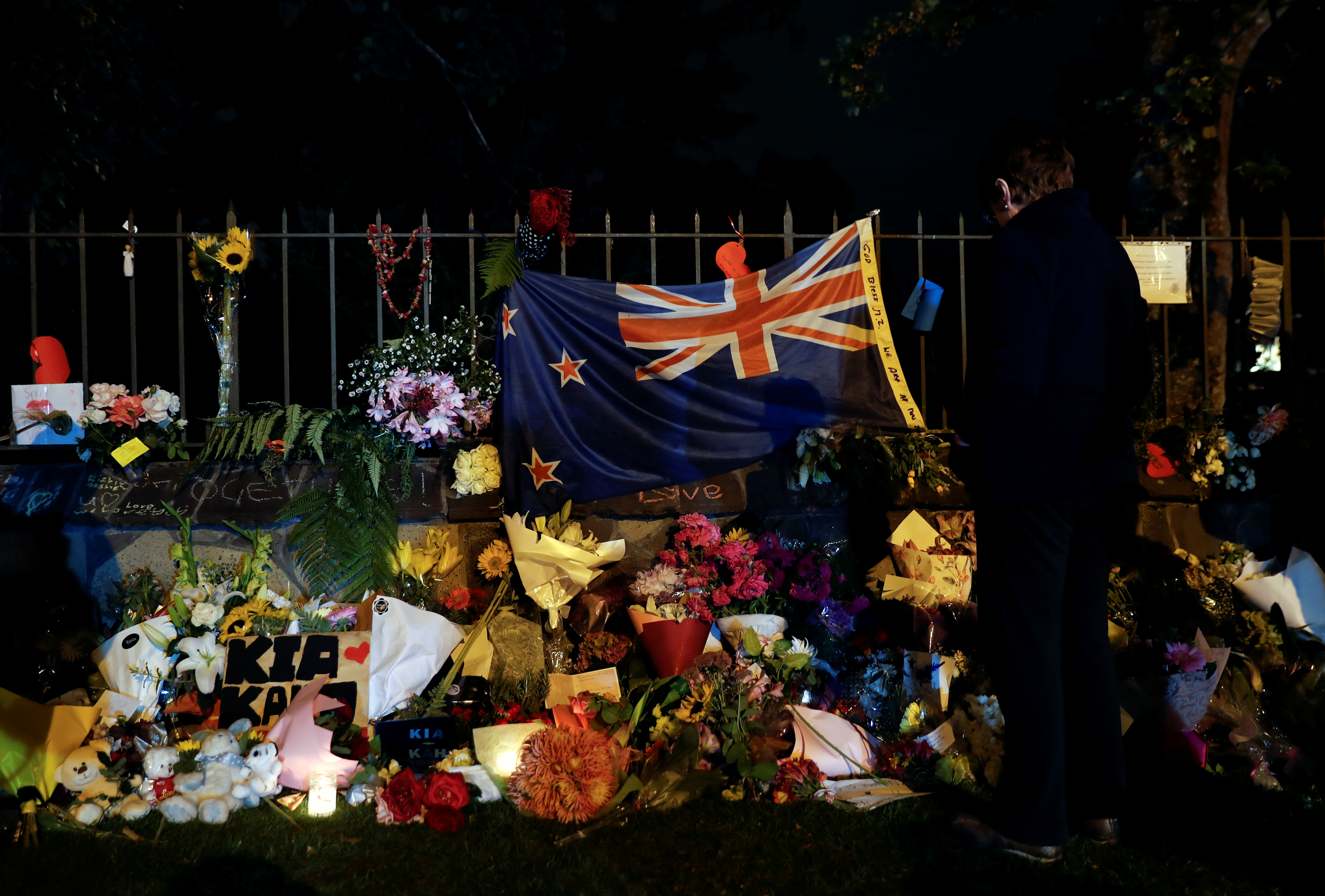 علم نيوزلندا وباقات الزهور يزينان النصب التذكارى للهجوم
