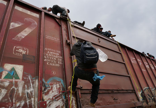 جحافل-المهاجرين-يتسلقون-قطار-تجارى-(8)