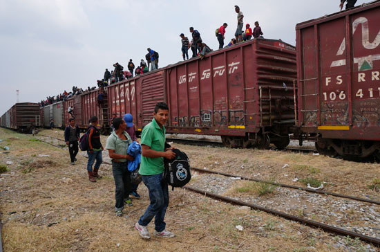 جحافل-المهاجرين-يتسلقون-قطار-تجارى-(9)