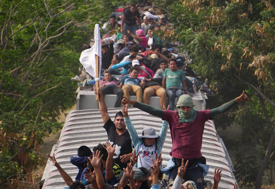 جحافل-المهاجرين-يتسلقون-قطار-تجارى-(2)