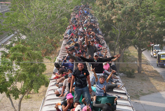 جحافل-المهاجرين-يتسلقون-قطار-تجارى-(1)