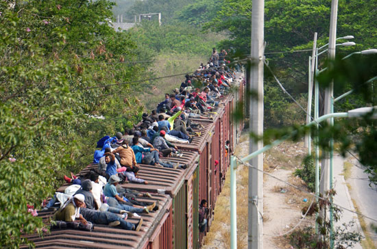 جحافل-المهاجرين-يتسلقون-قطار-تجارى-(3)