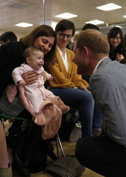 الأمير هارى يداعب طفلة