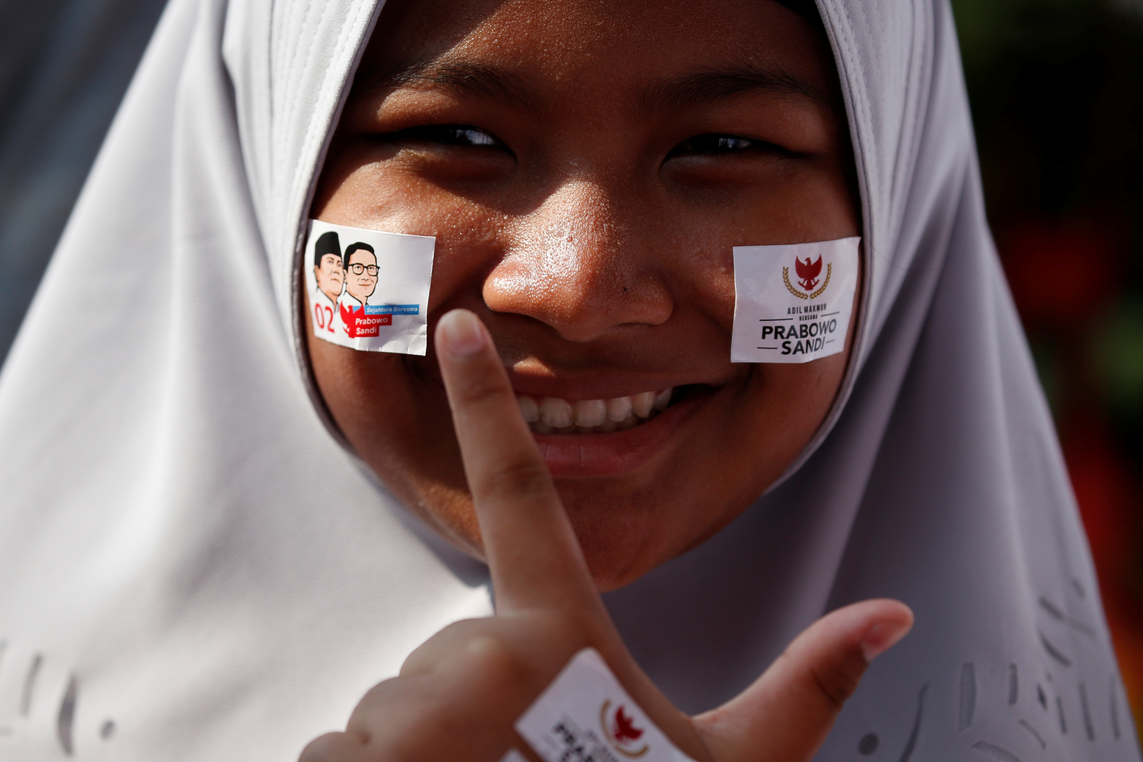 فتاة تضع ملصقات على وجهها لتأييد مرشحها