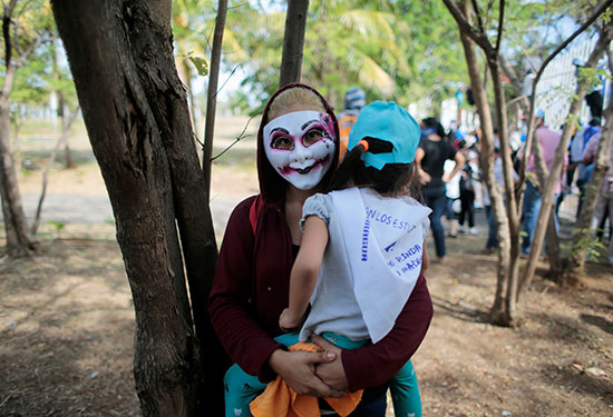 متظاهرة تحمل ابنتها خلال مسيرة ضد حكومة نيكاراجوا