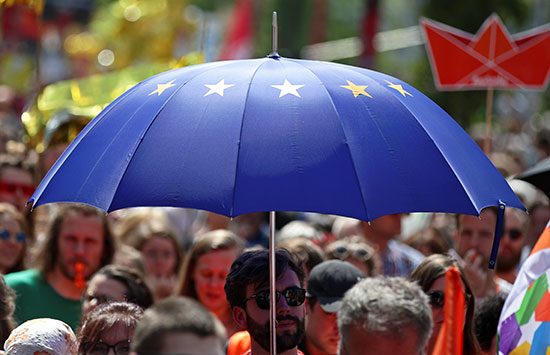 متظاهر يحمل مظلة بشعار الاتحاد الأوروبى