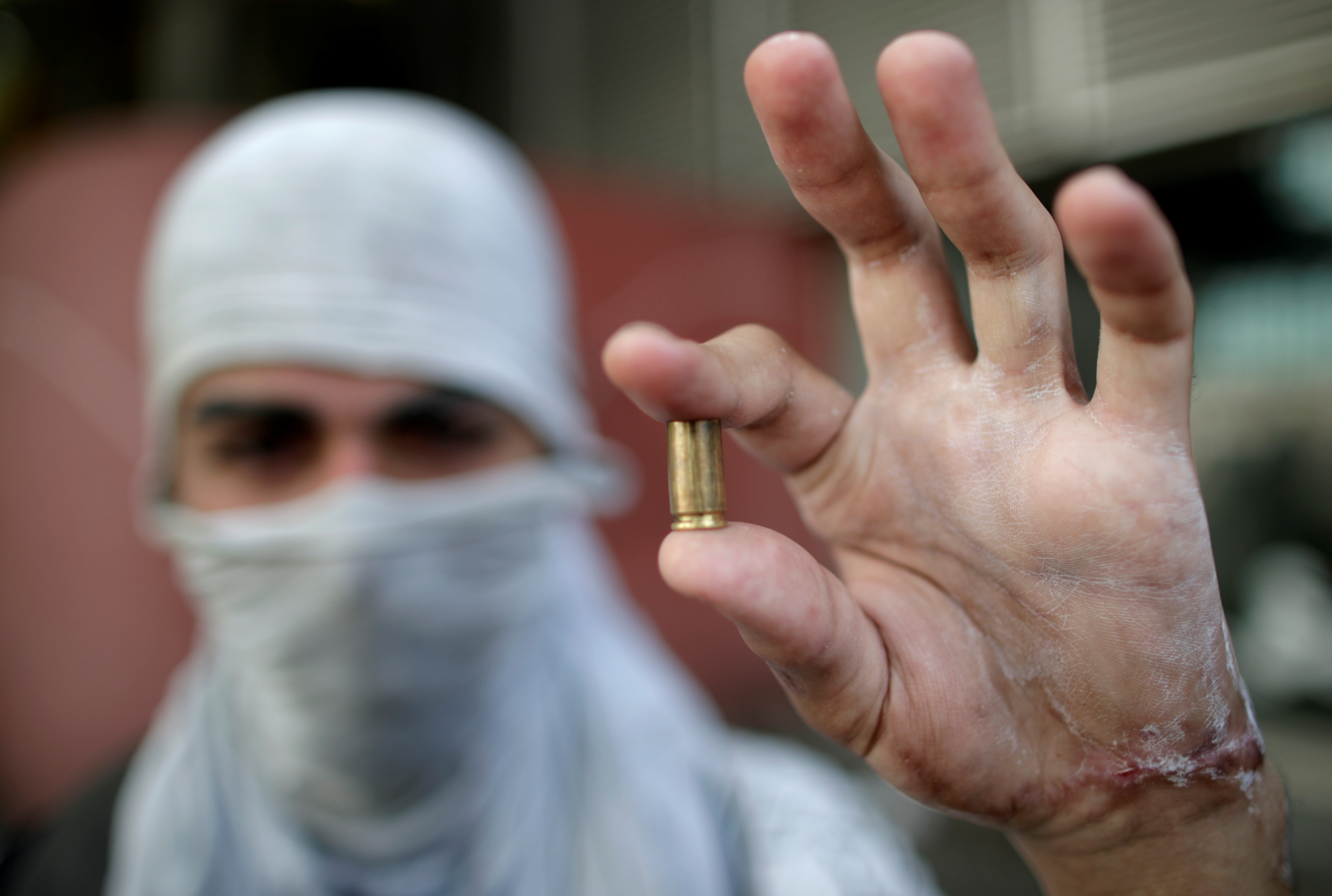 متظاهر يحمل طلقة لإثبات استخدام الأمن للرصاص الحى