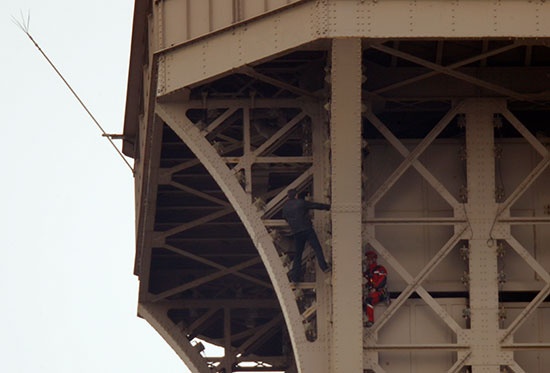 الشاب يبتعد عن رجل الإنقاذ اعلى برج إيفل
