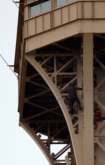 رجل إنقاذ يحاول الوصول إلى الشاب أعلى برج إيفل