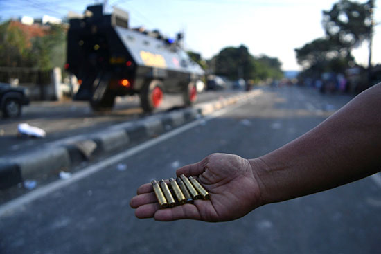 متظاهر إندونيسى يظهر فوارغ الرصاص بعد تفريق الاحتجاجات