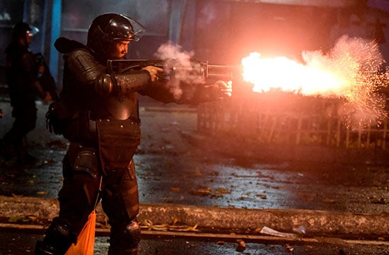 شرطى إندونيسى يواجه المتظاهرين بقنابل الغاز