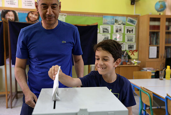صفل يضع بطاقة الاقتراع الخاصة بأبيه فى صندوق الانتخابات