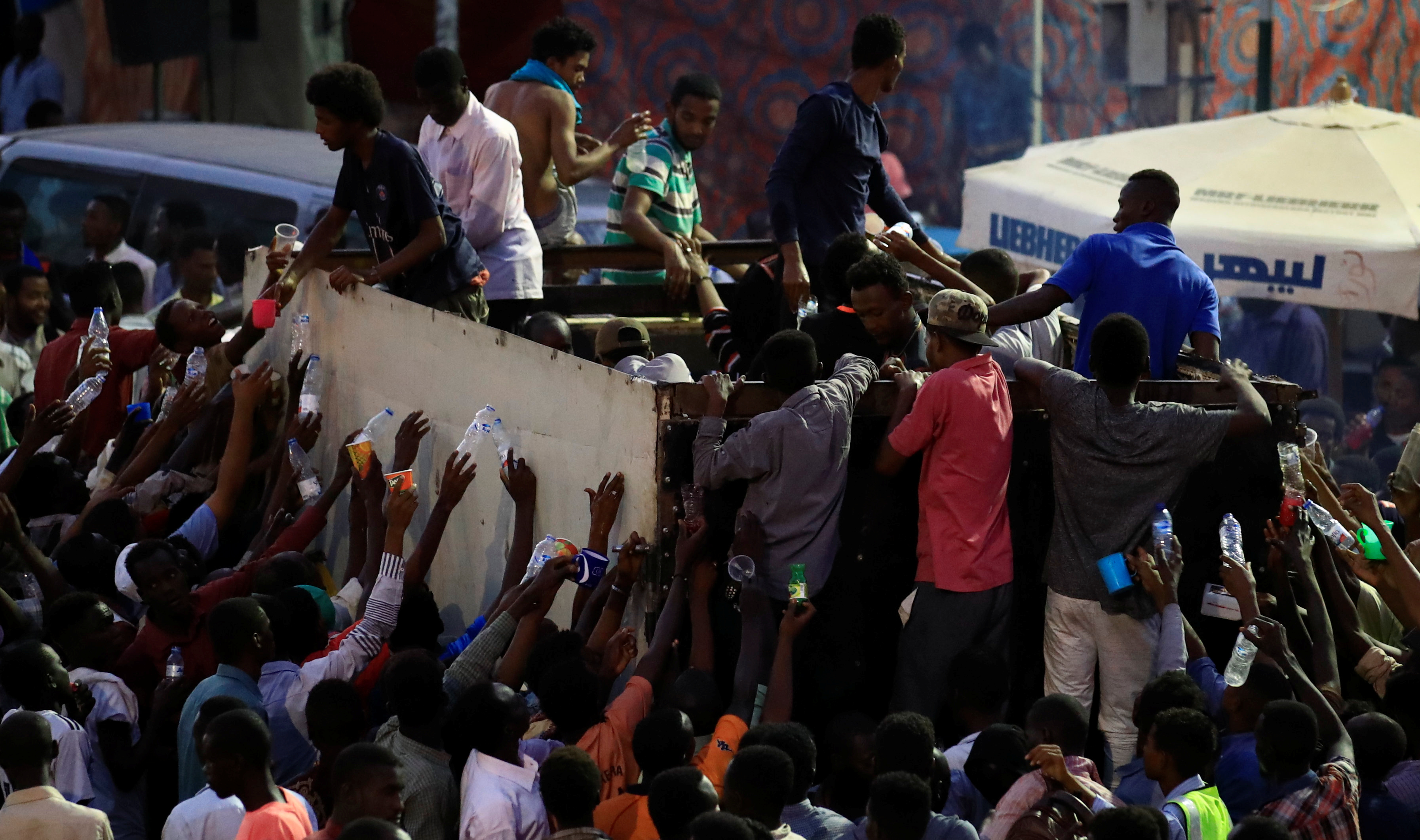 سودانيون يوزعون زجاجات المياه فى الشوارع