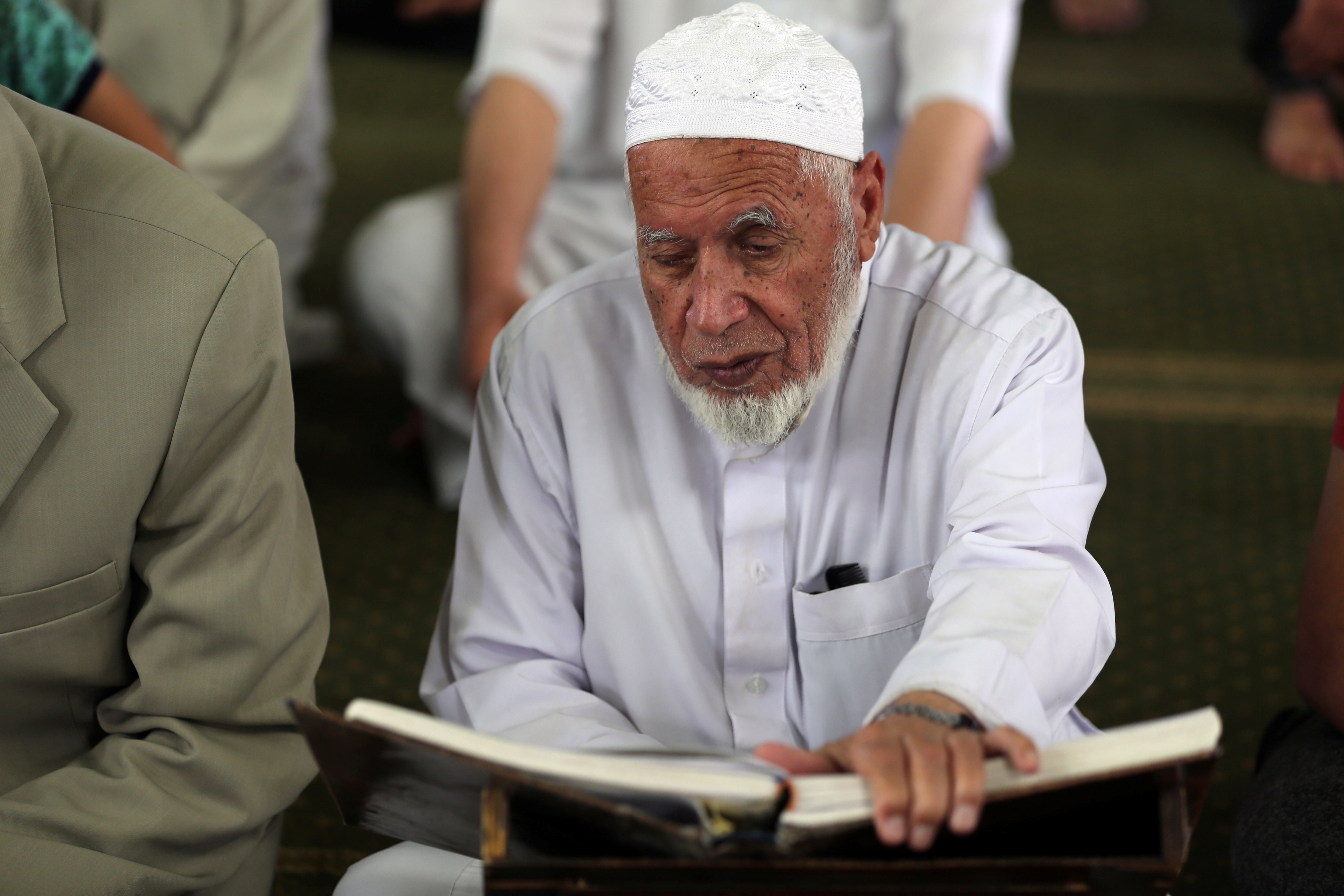 مسن فلسطينى يقرأ القرآن قبل كسر صيامه فى غزة