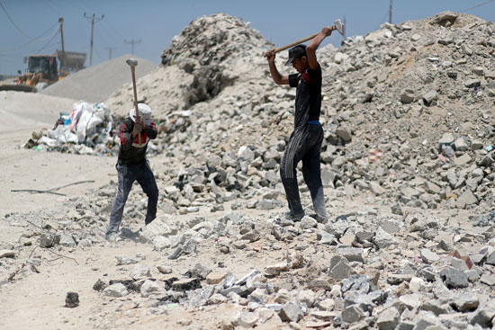 عمال-فلسطينيون-يكسرون-الحجر-لإعادة-استخدامه-فى-البناء