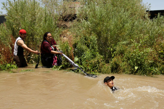 مهاجرون غير شرعيون يسحبون زميلهم من النهر