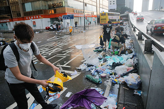 اشخاص يزيلون مخلفات اعتصامهم فى هونج كونج