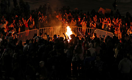 المتظاهرت يلتففن حول شعلة من النيران