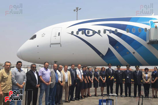 عدد من موظفي مصر للطيران بجانب الطائرة
