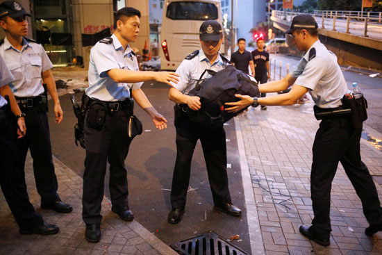 شرطة هونج كونج تحمل حقائب تركها المتظاهرين