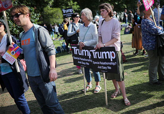 متظاهرون يحملون اللافتات ضد ترامب