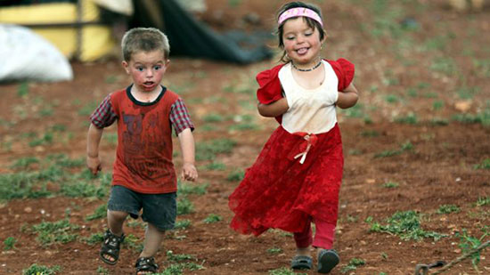 طفلان من المهاجرين السوريين يحتفلات بقدوم العيد في ريف محافظة إدلب