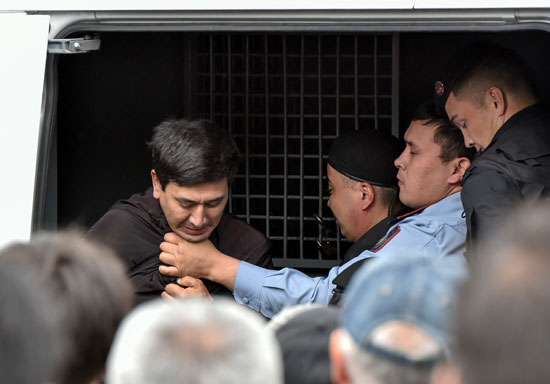 احتجاز متظاهر فى سيارة للشرطة بكازاخستان