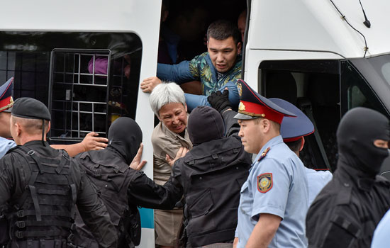 احتجاز متظاهرة داخل سيارة الشرطة بكازاخستان
