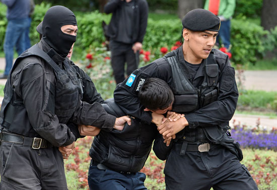 شرطى يسيطر على متظاهر فى كازاخستان