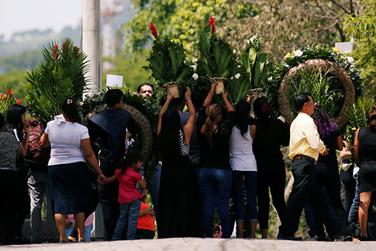 المشاركون فى الجنازة يرفعون اكاليل الورد على روح المواطن السلفادورى وابنته