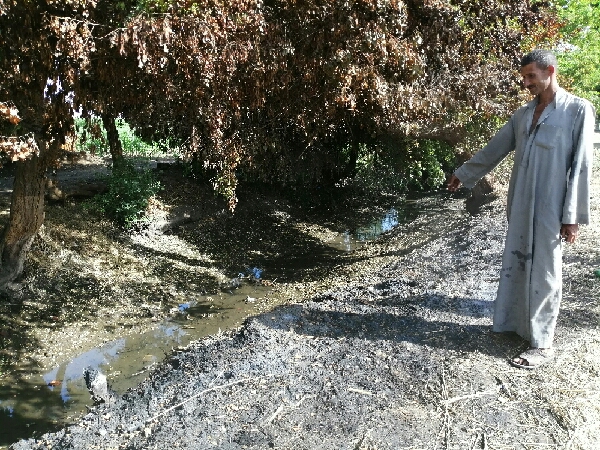 مزارع يشير الى مكان القاء ماكينات الرى بالترعة