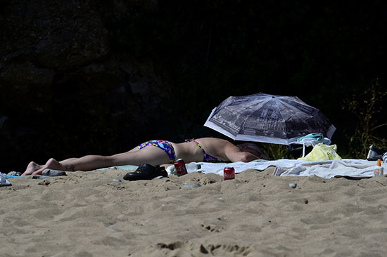 أوروبية تفترش الرمال بأحد الشواطئ