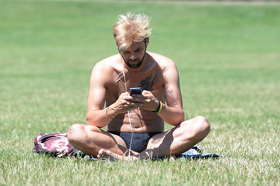 رجل يجلس بأحد الحدائق بدون ملابسه بسبب الطقس الحار