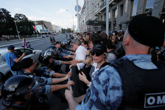 Russian anti riots police pushes the demonstrators away from the street