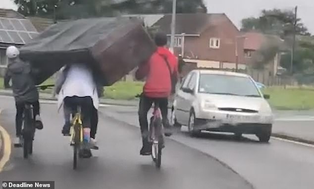 أربع أصدقاء يحملون أريكة أثناء سفرهم بالدراجات (2)